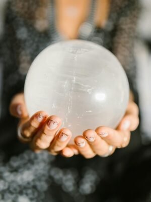 Close-up of hands holding a clear crystal ball, ideal for spiritual or metaphysical themes.